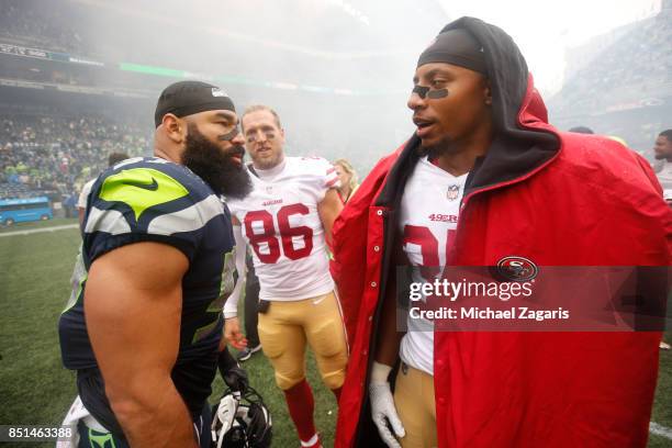 Michael Wilhoite of the Seattle Seahawks and Eric Reid of the San Francisco 49ers talk on the field following the game at CenturyLink Field on...