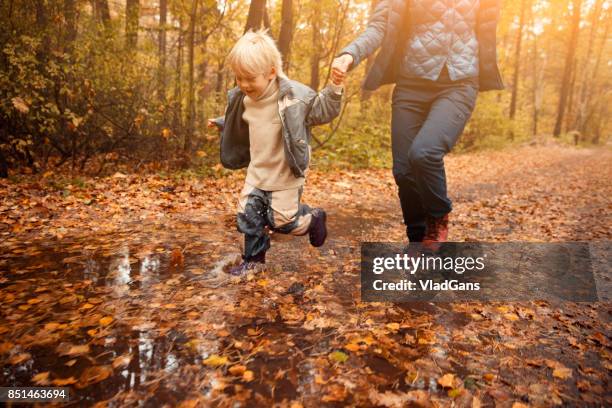 mother and child in the park - russia rain boots imagens e fotografias de stock