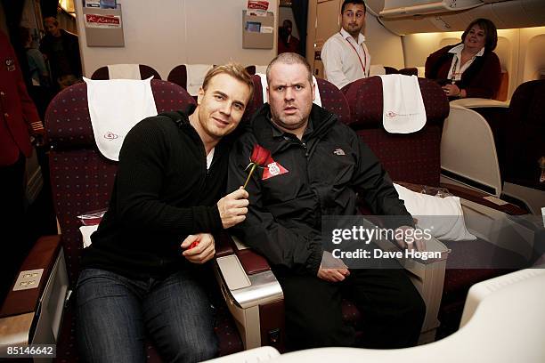 Gary Barlow gives a rose to Chris Moyles after boarding a flight to Tanzania to climb Mount Kilimanjaro in aid of Comic Relief at Heathrow Terminal 4...