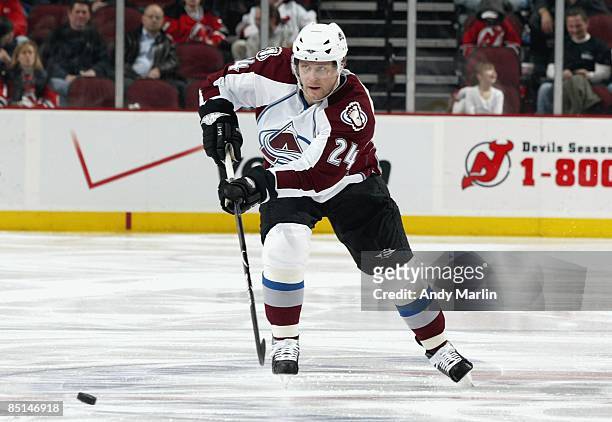 Rusian Salei of the Colorado Avalanche passes the puck against the New Jersey Devils at the Prudential Center on February 26, 2009 in Newark, New...