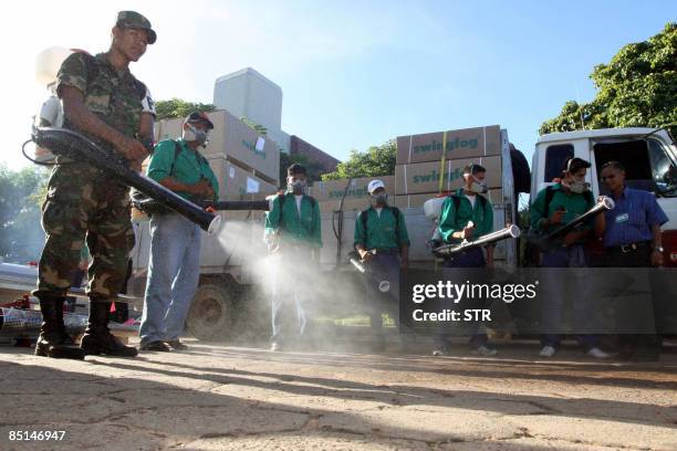 Soldier and municipal workers fumigate along a street against mosquitos, vectors of the dengue fever, in Santa Cruz, eastern Bolivia, on February 27,...