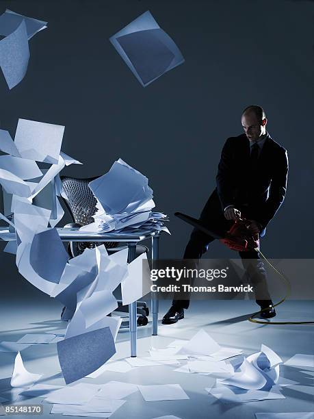 businessman cleaning papers with leaf blower - laubbläser stock-fotos und bilder