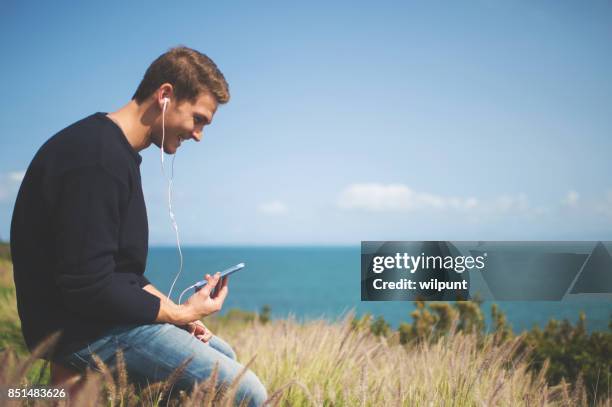 male listening to podcast - electronic listening device stock pictures, royalty-free photos & images