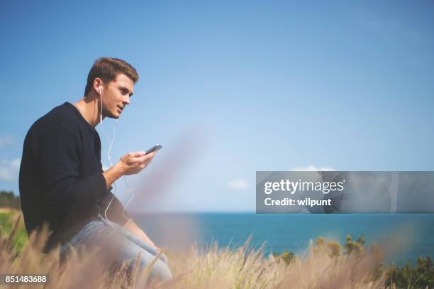 male listening to podcast - electronic listening device stock pictures, royalty-free photos & images