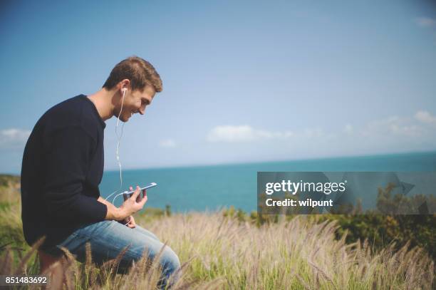 male listening to podcast - electronic listening device stock pictures, royalty-free photos & images