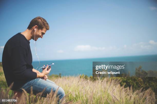 male listening to podcast - electronic listening device stock pictures, royalty-free photos & images