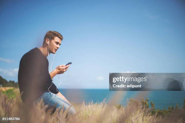 male listening to podcast - electronic listening device stock pictures, royalty-free photos & images