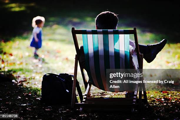 man sitting in a deckchair - deck chair stock pictures, royalty-free photos & images