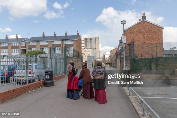 Women walking towards Balfron Tower on 27th April 2016 in London, United Kingdom. The architecturally important Balfron Tower is a 26-storey...