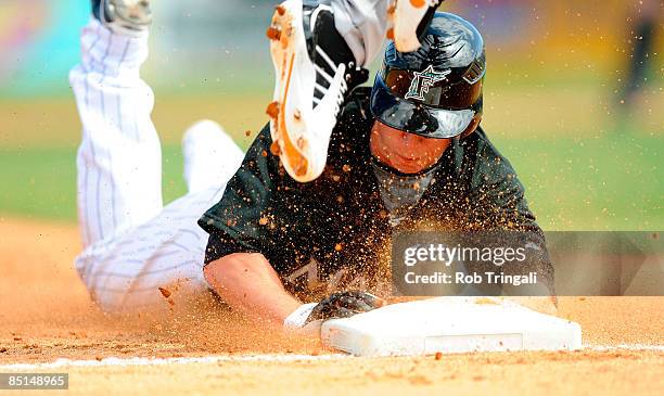 John Raynor of the Florida Marlins slides head first after stealing third base against the Baltimore Orioles during a spring training game at Roger...