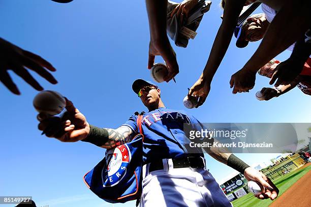 Josh Hamilton of the Texas Rangers gives autographs before the start of a spring training game against the Chicago Cubs at the Surprise Stadium on...