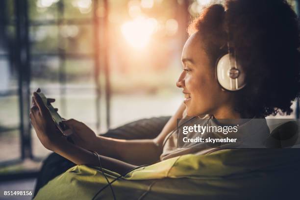 happy african american woman enjoying in good music over cell phone. - mp3 player stock pictures, royalty-free photos & images