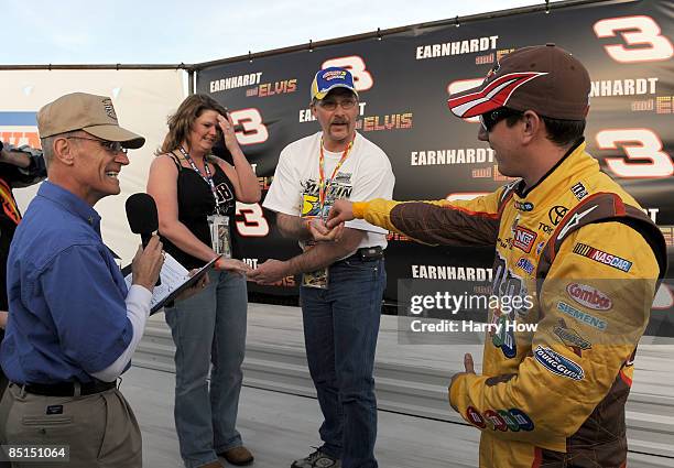 Kyle Busch, driver of the M & M's Toyota, hands the ring to Damon and Heather Landry as chaplin Bruce Brown performs their wedding ceremony during...