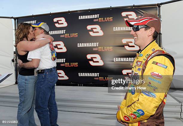 Kyle Busch, driver of the M & M's Toyota, smiles as Damon and Heather Landry kiss during their wedding ceremony during qualifying for the NASCAR...