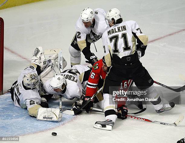 Rusian Fedotenko of the Pittsburgh Penguins slides into goaltender Marc-Andre-Fleury after Fleury saved a shot by Andrew Ladd of the Chicago...