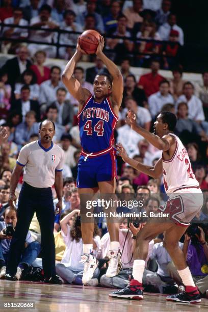 Rick Mahorn of the Detroit Pistons passes the ball against Bill Cartwright of the Chicago Bulls circa 1989 at Chicago Stadium in Chicago, Illinois....