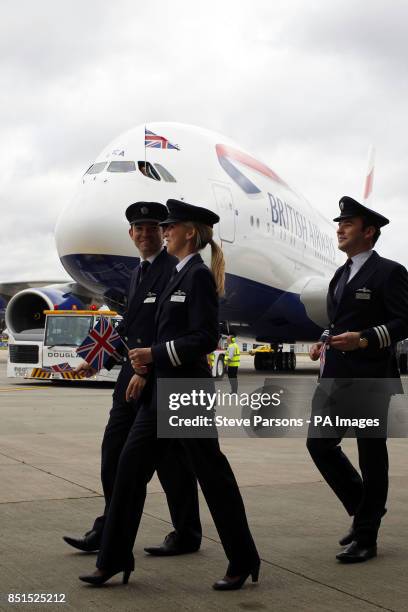 British Airways pilots walk in front of a British Airways Airbus A380, the world's largest passenger plane, at Heathrow Airport, as BA became the...