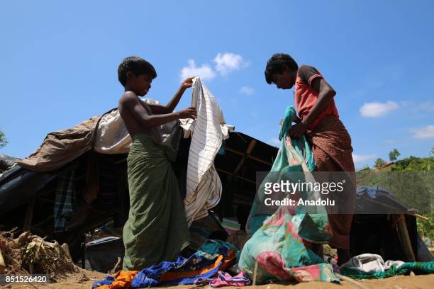 Rohingya Muslim children, fled from ongoing military operations in Myanmars Rakhine state, search usable clothes near a tent at a makeshift camp in...