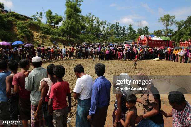 Rohingya Muslims, fled from ongoing military operations in Myanmars Rakhine state, stand in line to receive humanitarian aids at a makeshift camp in...