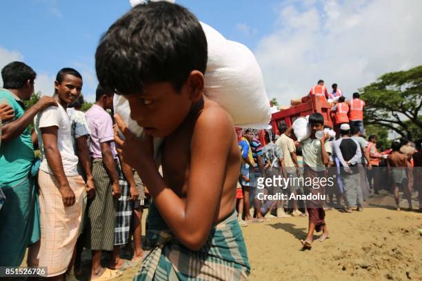 Rohingya Muslim child, fled from ongoing military operations in Myanmars Rakhine state, carries a bag of humanitarian aid at a makeshift camp in...