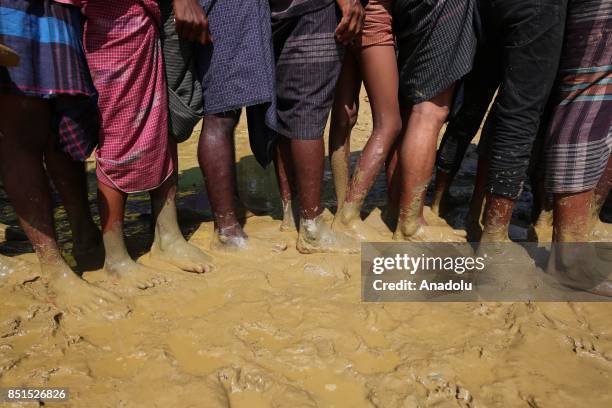 Rohingya Muslims, fled from ongoing military operations in Myanmars Rakhine state, stand in line to receive humanitarian aids at a makeshift camp in...