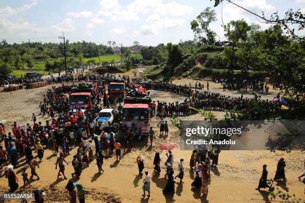 Rohingya Muslims, fled from ongoing military operations in Myanmars Rakhine state, stand in line to receive humanitarian aids at a makeshift camp in...