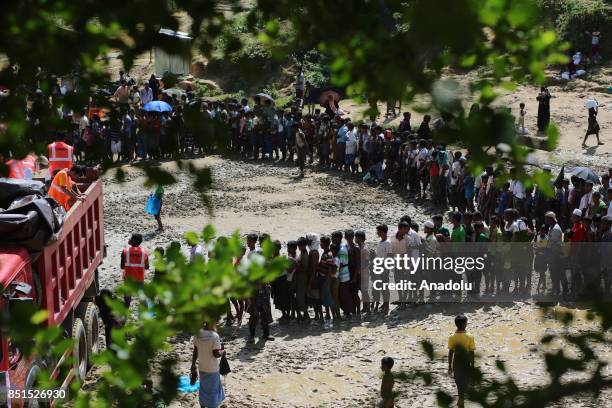 Rohingya Muslims, fled from ongoing military operations in Myanmars Rakhine state, stand in line to receive humanitarian aids at a makeshift camp in...