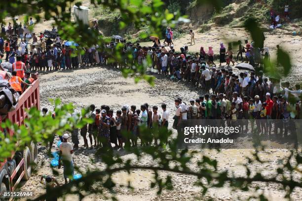 Rohingya Muslims, fled from ongoing military operations in Myanmars Rakhine state, stand in line to receive humanitarian aids at a makeshift camp in...