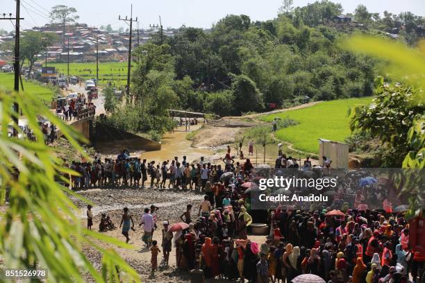 Rohingya Muslims, fled from ongoing military operations in Myanmars Rakhine state, stand in line to receive humanitarian aids at a makeshift camp in...