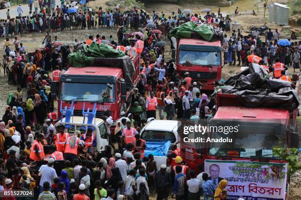 Rohingya Muslims, fled from ongoing military operations in Myanmars Rakhine state, stand in line to receive humanitarian aids at a makeshift camp in...