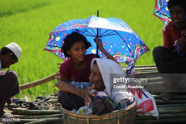 Rohingya Muslim women, fled from ongoing military operations in Myanmars Rakhine state, sit inside of a bucket at a makeshift camp in Teknaff,...