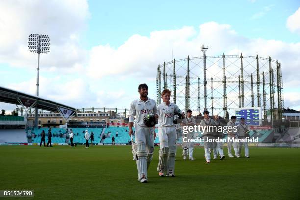 Ben Foakes and Ollie Pope of Surrey leave the field after making the final runs to win the match for Surrey during day four of the Specsavers County...