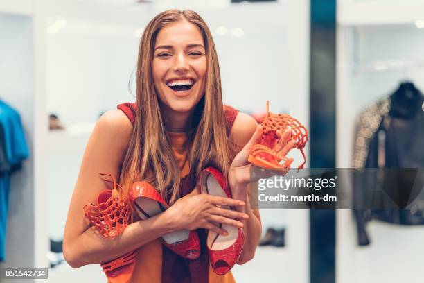 mujer atractiva en la zapatería con un montón de zapatos nuevos - zapatos mujer fotografías e imágenes de stock