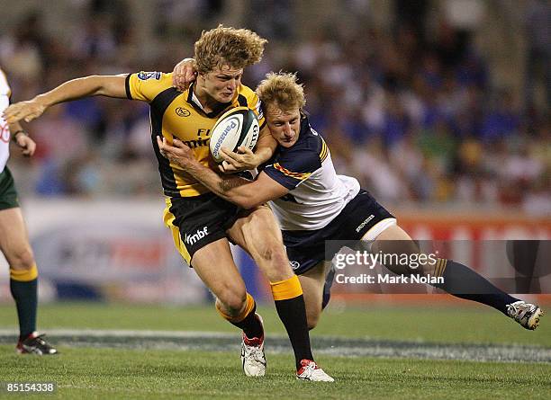 Patrick Phibbs of the Brumbies tackles Nick Cummins of the Force during the round three Super 14 match between the Brumbies and the Western Force at...