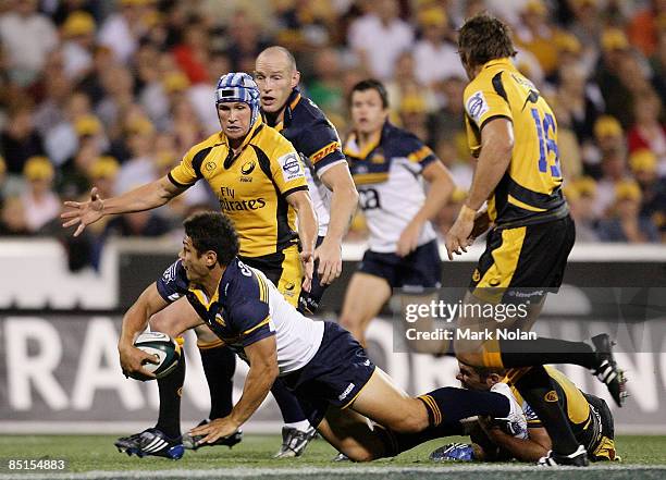 Tyrone Smith of the Brumbies looks to pass as Matt Giteau of the Force covers in defence during the round three Super 14 match between the Brumbies...