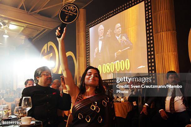 Woman from India makes her bid at EUR 80.000 for a handcrafted Cohiba humidor during an auction and gala dinner at the end of the annual five day...