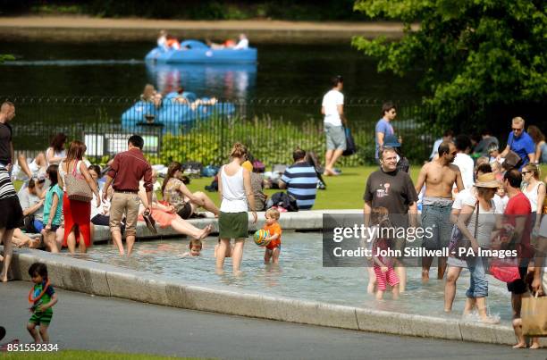 People cool off in the Diana Princess of Wales Memorial Fountain in Hyde Park central London, as hot weather hits the capital city.