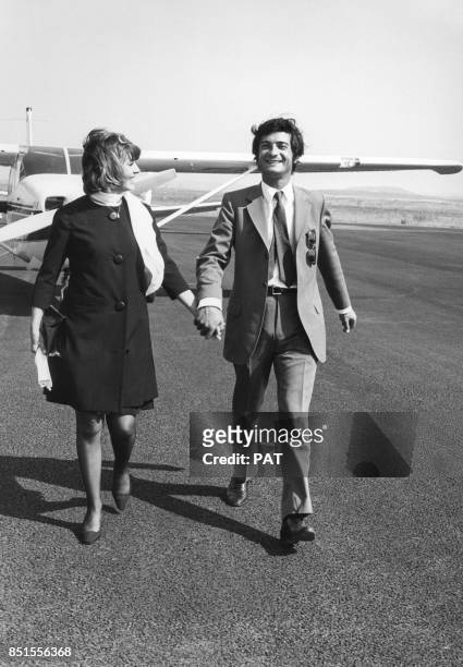 Jeanne Moreau et Jean-Claude Brialy descendent d'un avion en se tenant la main à l'aéroport de Nice le 13 juillet 1967, France.
