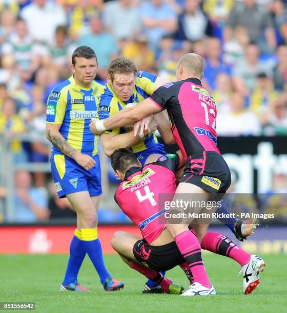 Warrington Wolves' Joel Monaghan is tackled by Leeds Rhinos Joel Moon and Carl Ablett during the Super League match at the Halliwell Jones Stadium,...