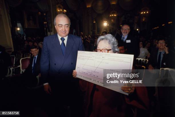 La romancière Marguerite Duras montre le chèque qui accompagne le Prix Hemingway 1986 à l'Hôtel Ritz le 7 avril 1986 à Paris, France.