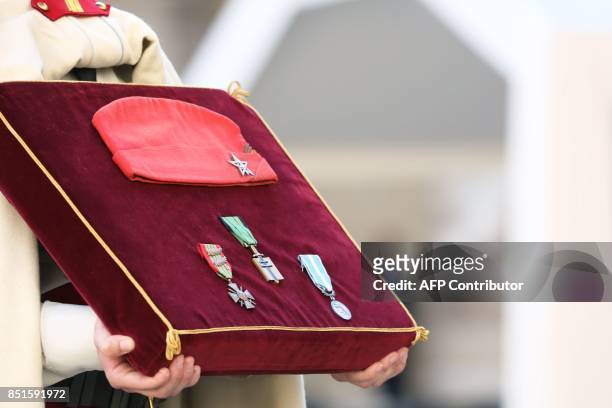 French soldier holds the military decorations of late French WWII colonel Fred Moore, including the Croix de guerre 19391945, the Croix de l'ordre de...