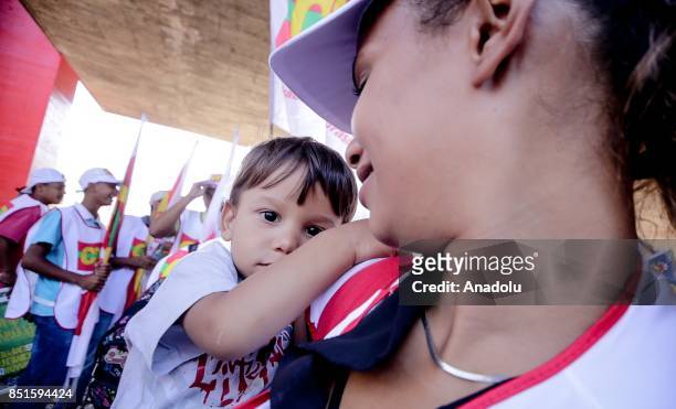 Woman holds a baby during a demonstration organised by the Central of Brazil's Workers and the other trade union centrals with demonstrators carrying...