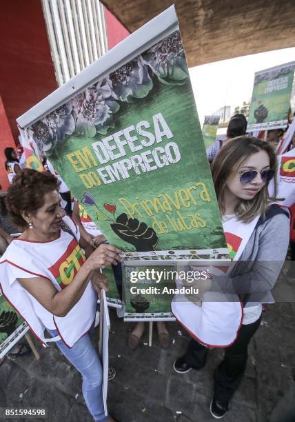 People hold banners during a demonstration organised by the Central of Brazil's Workers and the other trade union centrals with demonstrators...