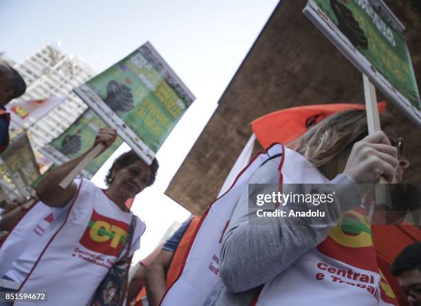 People hold banners during a demonstration organised by the Central of Brazil's Workers and the other trade union centrals with demonstrators...