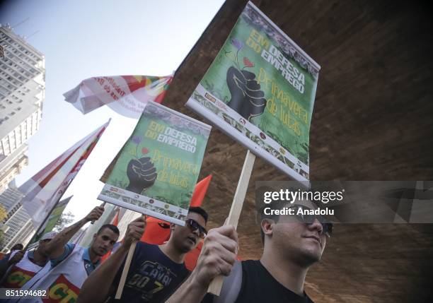 People hold banners during a demonstration organised by the Central of Brazil's Workers and the other trade union centrals with demonstrators...