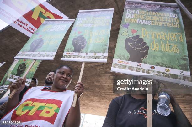 People hold banners during a demonstration organised by the Central of Brazil's Workers and the other trade union centrals with demonstrators...