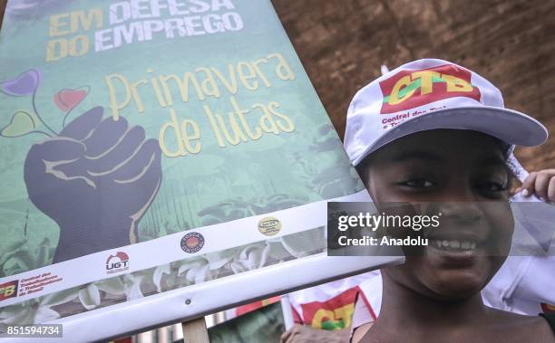 Little boy stands next to a banners during a demonstration organised by the Central of Brazil's Workers and the other trade union centrals with...