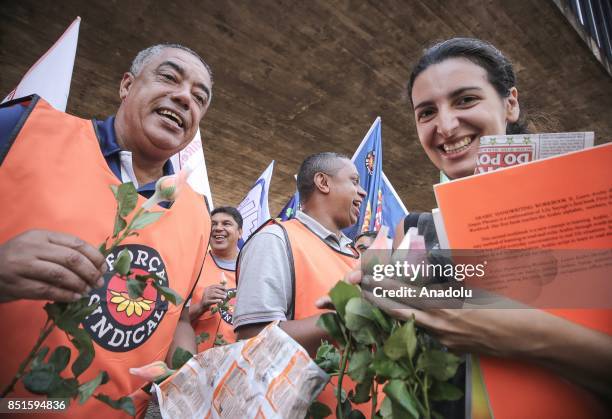 Demonstrators distribute flowers during a demonstration organised by the Central of Brazil's Workers and the other trade union centrals with...