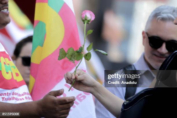 Man hands a flower out during a demonstration organised by the Central of Brazil's Workers and the other trade union centrals with demonstrators...