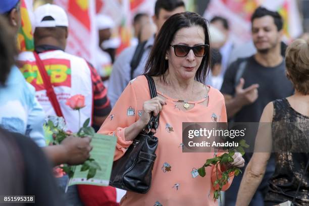 Woman holds a flower during a demonstration organised by the Central of Brazil's Workers and the other trade union centrals with demonstrators...